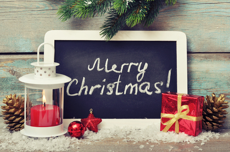 Christmas  decoration with candle in lantern and framed blackboard on wooden backgroundの写真素材