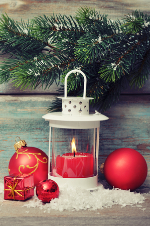 Christmas  decoration with candle in lantern and fir tree branches on wooden backgroundの写真素材