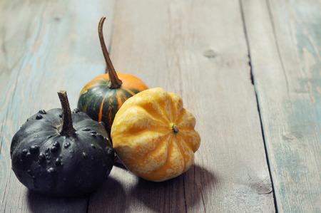 Three small decorative pumpkins over wooden backgroundの写真素材