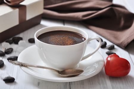 Hot Chocolate in cup with cocoa powder and red stone heart on wooden backgroundの写真素材