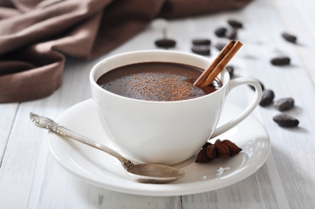 Hot Chocolate in cup with cocoa powder and cinnamon stick on wooden backgroundの写真素材