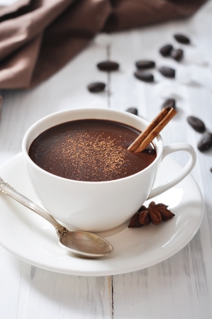Hot Chocolate in cup with cocoa powder and cinnamon stick on wooden backgroundの写真素材