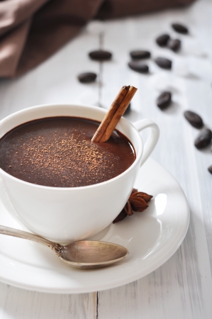 Hot Chocolate in cup with cocoa powder and cinnamon stick on wooden backgroundの写真素材