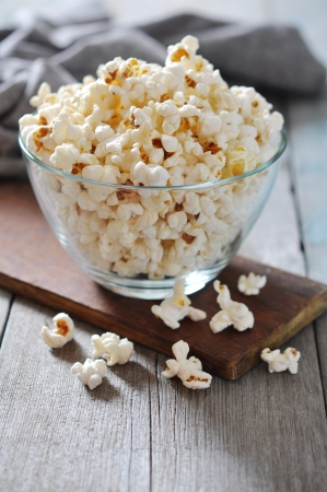 Popcorn in glass bowl over wooden backgroundの写真素材