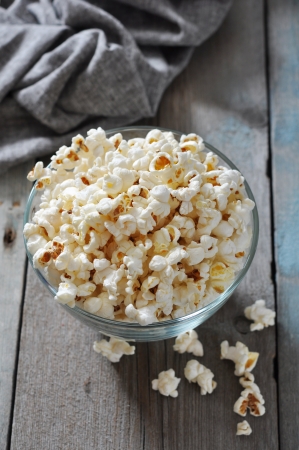 Popcorn in glass bowl over wooden backgroundの写真素材