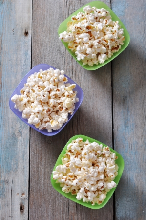 Popcorn in plastic bowls over wooden backgroundの写真素材