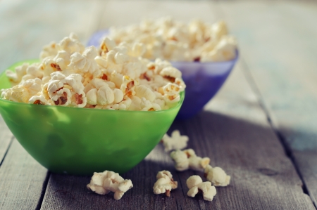 Popcorn in plastic bowls over wooden backgroundの写真素材
