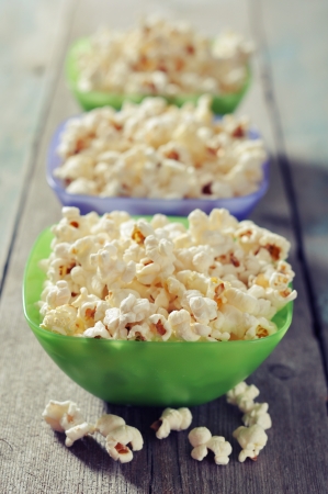 Popcorn in plastic bowls over wooden backgroundの写真素材