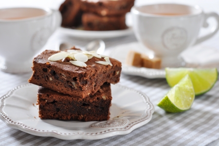 Brownie cake with almond flakes and cup of tea closeupの写真素材