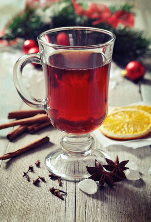 Mulled wine with spices and christmas decoration on wooden backgroundの写真素材
