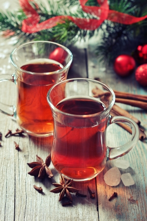 Mulled wine with spices and christmas decoration on wooden backgroundの写真素材