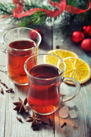 Mulled wine with spices and christmas decoration on wooden backgroundの写真素材