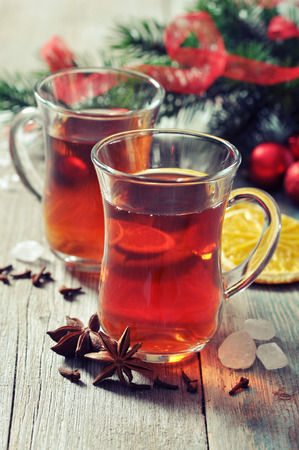Mulled wine with spices and christmas decoration on wooden backgroundの写真素材