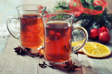 Mulled wine with spices and christmas decoration on wooden backgroundの写真素材