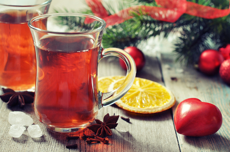 Mulled wine with spices and christmas decoration on wooden backgroundの写真素材