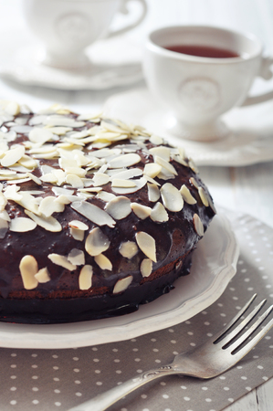 Chocolate cake on vintage plate with cup of teaの写真素材
