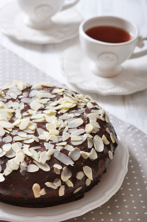 Chocolate cake on vintage plate with cup of teaの写真素材