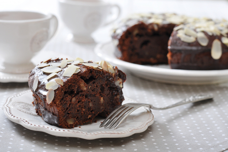 Chocolate cake with almond on vintage plate with cup of teaの写真素材