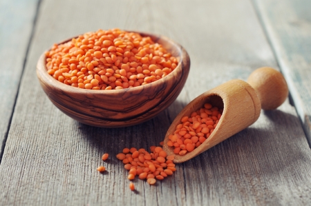 Lentils in wooden bowl with scoop on wooden background closeupの写真素材