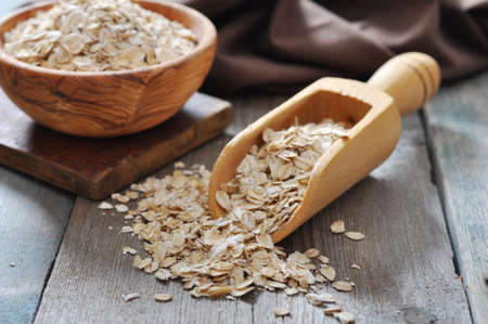 oat flakes in wooden  scoop on wooden background の写真素材