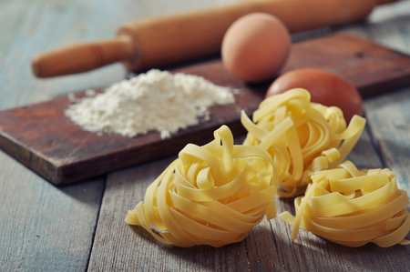Flour, pasta and rolling-pin on wooden background の写真素材