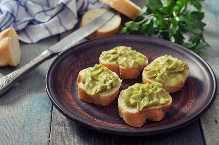 Delicious appetizer canapes of bread and guacamole served with parsley closeupの写真素材