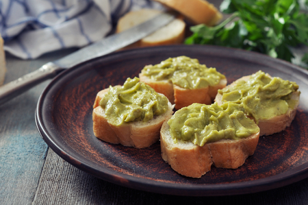 Delicious appetizer canapes of bread and guacamole served with parsley closeupの写真素材
