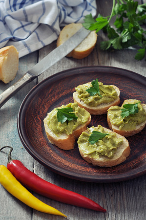Delicious appetizer canapes of bread and guacamole served with parsley closeupの写真素材