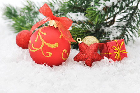 Red christmas ball and fir branches with decorations on snowの写真素材