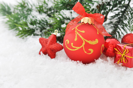 Red christmas ball and fir branches with decorations on snowの写真素材