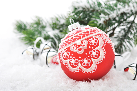 Red christmas ball and fir branches with decorations on snowの写真素材
