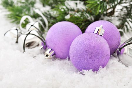 Pink christmas balls and fir branches with decorations on snowの写真素材