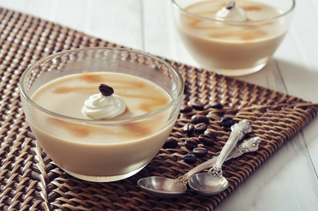 Dairy dessert with coffe flavor in glass bowl and spoons on wooden backgroundの写真素材