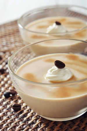 Dairy dessert with coffe flavor in glass bowl and spoons on wooden backgroundの写真素材