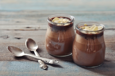 Chocolate dessert panna cotta with almond in glass jars on wooden backgroundの写真素材
