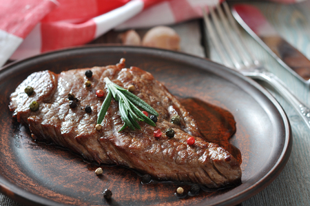 Grilled steak  on plate  with tomatoes, spices and rosemary closeupの写真素材