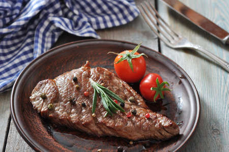 Grilled steak  on plate  with tomatoes, spices and rosemary closeupの写真素材