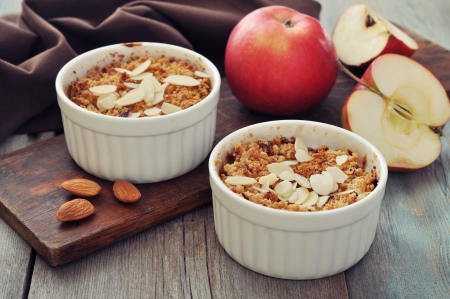 Apple crumble in ceramic molds with fresh apples on wooden backgroundの写真素材