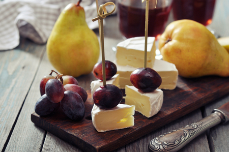 Canape with camembert cheese and grape on wooden backgroundの写真素材