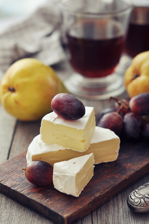 Camembert cheese and fresh fruits on wooden backgroundの写真素材