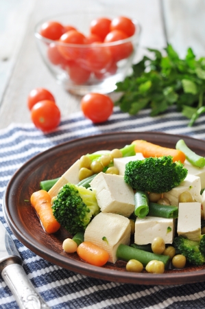 Tofu with  boiled vegetables on plate and tomatos closeupの写真素材