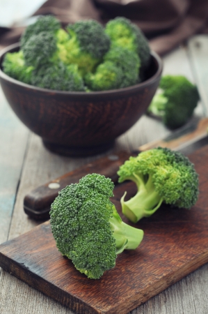 Bunch of fresh green broccoli in brown bowl over wooden backgroundの写真素材