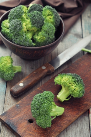 Bunch of fresh green broccoli in brown bowl over wooden backgroundの写真素材