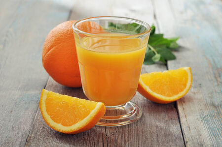 Orange juice in glass with mint,  fresh fruits on wooden backgroundの写真素材