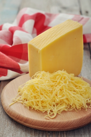 Grated cheese on wooden cutting board closeupの写真素材