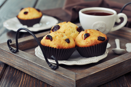 Muffins with dried cranberry on vintage wooden tray closeupの写真素材