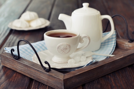 Cup of tea and teapot on wooden tray closeupの写真素材