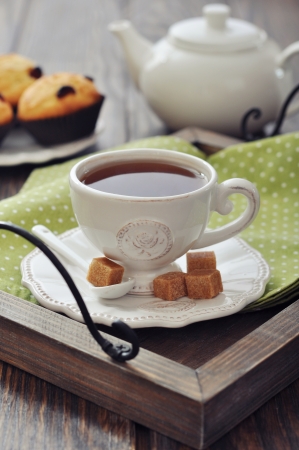 Cup of tea and teapot on wooden tray closeupの写真素材