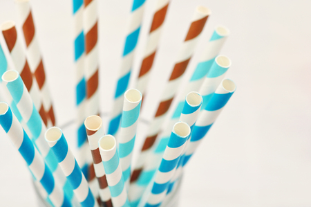 Striped drink straws of different colors in glass closeup. Selective focus.の写真素材
