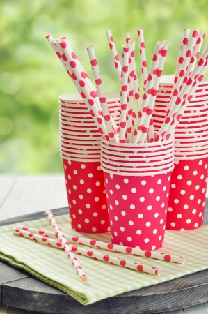 Red paper cups and striped straws for birthday party. の写真素材